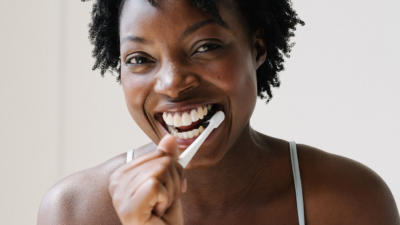 Woman brushing her teeth and smiling